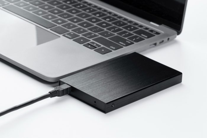 a black hard drive connecting to a laptop