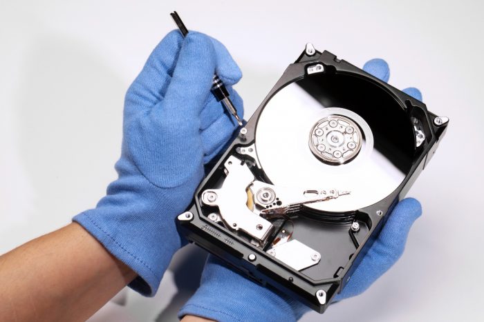 hands fixing a hard drive